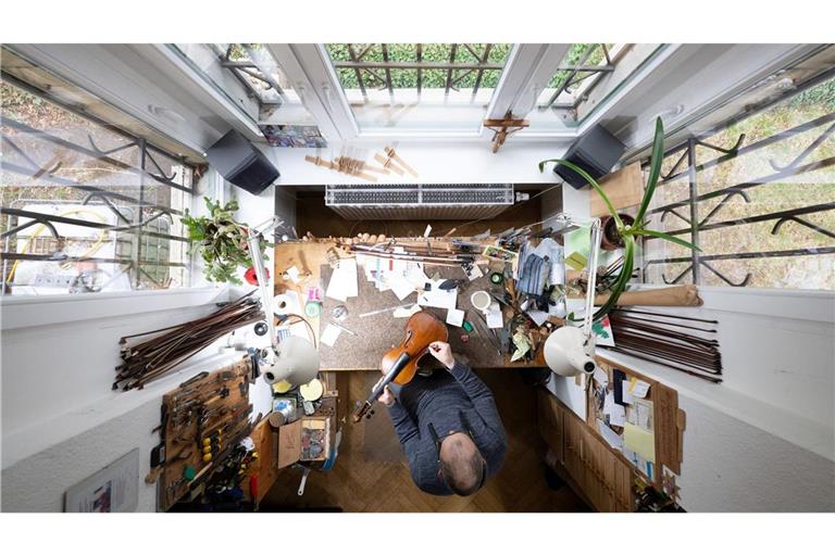 Kunsthandwerk von oben: Ein Geigenbauer arbeitet in einer Geigenwerkstatt an einer Bratsche.