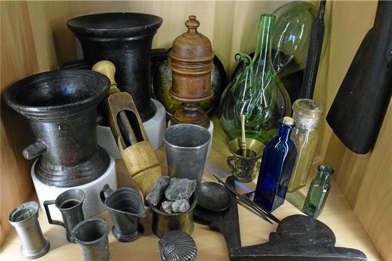 Laborgefäße, eine hölzerne Pillenpresse und weitere Gerätschaften aus der Apotheke werden in der Vitrine im CSM gezeigt. Foto: E. Klaper