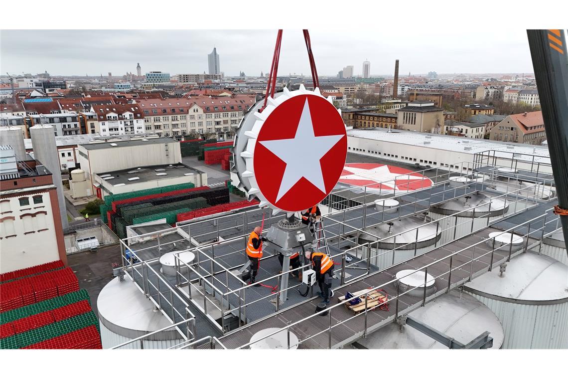Leipzig: Der Sterni-Kronkorken ist wieder da – Kran hebt Kult-Leuchtreklame aufs Brauhaus
