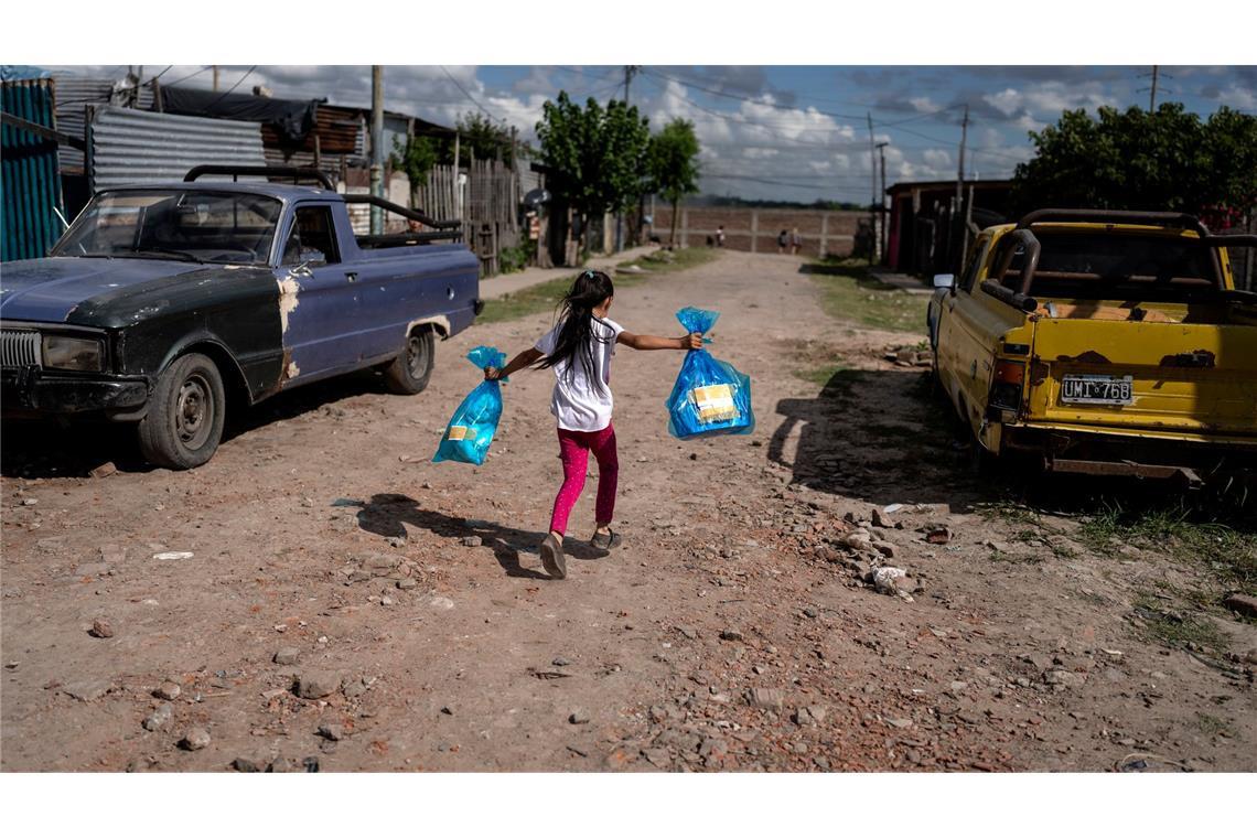Bilder des Tages Madeleine Bordon läuft mit Geschenken in der Hand nach Hause, die sie bei einer von der Suppenküche "Los Chicos de la Via" organisierten vorweihnachtlichen Feier in Buenos Aires erhalten hat.