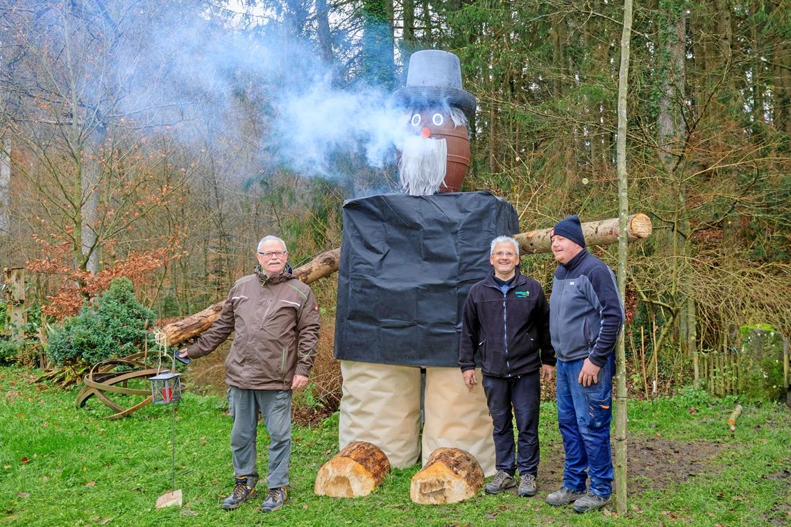 Manfred Krautter, Walter Hieber und Timo Hübner (von links) bei ihrem Mühlenweihnachtsbotschafter, dem wohl größten Räuchermann im Schwäbischen Wald. Foto: Stefan Bossow