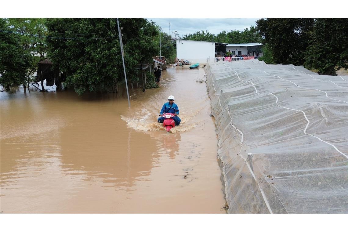 Mann kämpft sich auf überfluteter Straße durch die Fluten in Zentralvietnam