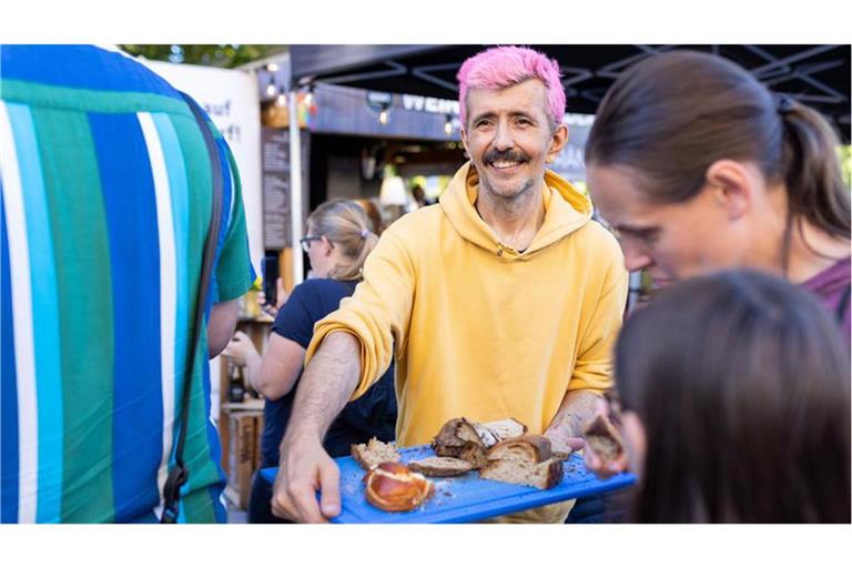 Marko Špehar-Piehler verteilt selbstgebackenes Brot auf dem Weindorf in Stuttgart.