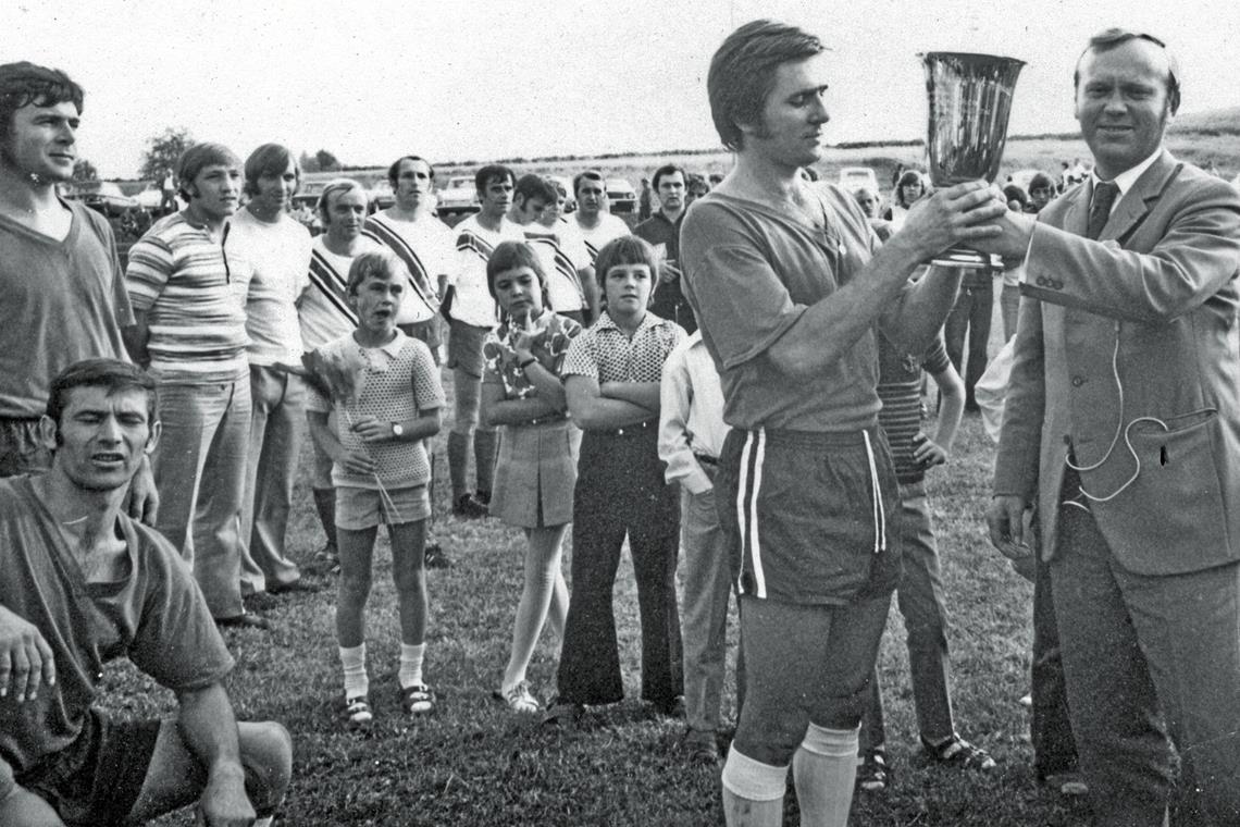 Zwei Tälesklubs sorgen für Furore Marschierten mit Lippoldsweiler binnen zehn Jahren von der C-Klasse in die 2. Amateurliga: Hans Herb (links), Helmut Hermann (unten) und Kapitän Bernd Schneider, dem der damalige Auenwalder Bürgermeister Walter Schmitt den Pokal für den Sieg beim Weissacher Tal-Turnier überreicht. Foto: privat: