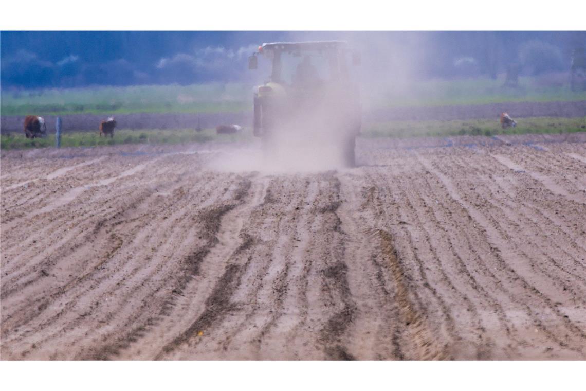 Stürme, Überschwemmungen, Hitze: 2024 war ein Extremjahr Mecklenburg-Vorpommern, Woosmer: Ein Traktor fährt über einen Acker und wirbelt eine Staubwolke auf. Fehlender Regen und kräftige Winde, die den Boden austrocknen, bereiten den Landwirten in Norddeutschland zunehmend Sorgen.