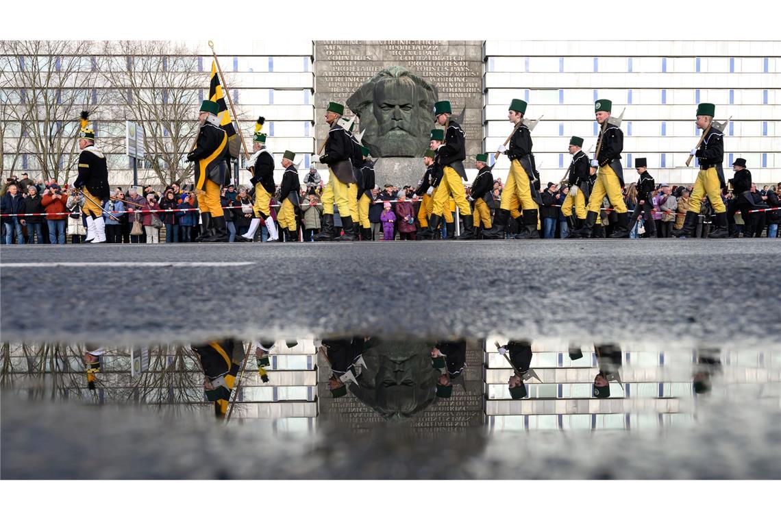 Mehr als 1000 Teilnehmer einer Bergparade ziehen im traditionellen Habit vor dem Karl-Marx-Monument in Chemnitz vorüber.