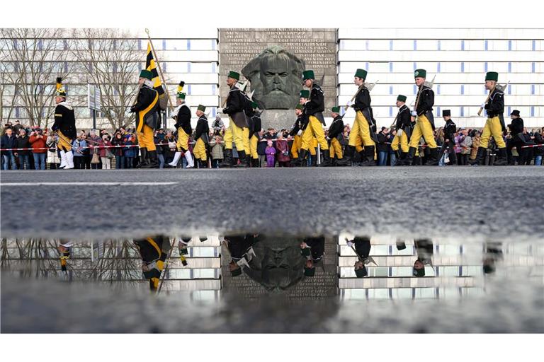 Mehr als 1000 Teilnehmer einer Bergparade ziehen im traditionellen Habit vor dem Karl-Marx-Monument in Chemnitz vorüber.