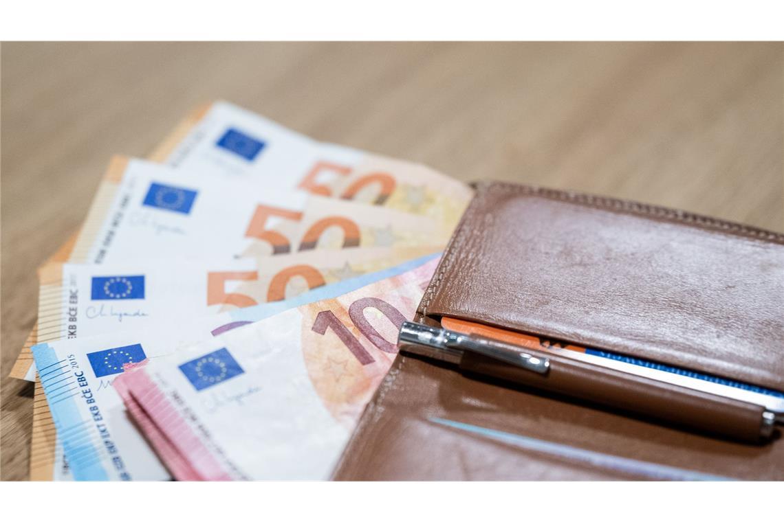 Mehrere Euro-Scheine liegen mit einer Geldbörse auf einem Tisch. (Symbolfoto)