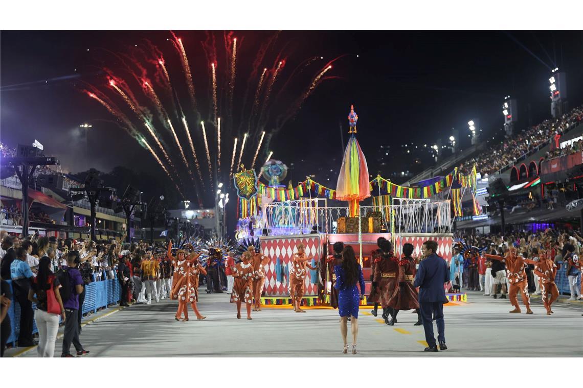Mehrere Sambaschulen ziehen mit bunten Wagen durch die Straße.