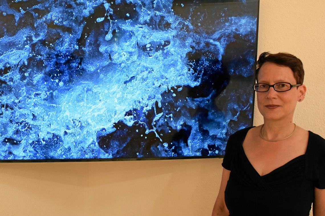 Melanie Wiora vor ihrem Video „Turmoil“, was so viel wie Aufruhr heißt. Damit die Wasserformationen des Bergflusses besser wahrnehmbar sind, hat sie den Film stark verlangsamt. Foto: Elisabeth Klaper