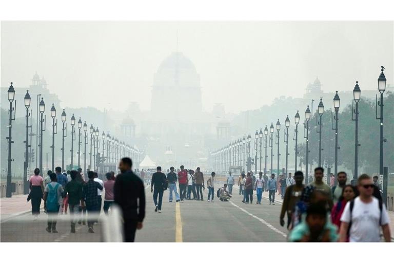 Menschen auf einer in Smog gehüllten Straße in Neu Delhi. (Archivbild)