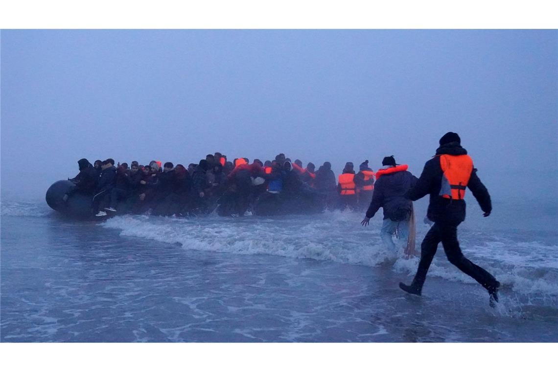 Menschen, bei denen es sich vermutlich um Migranten handelt, besteigen ein kleines Boot am Strand von Gravelines, Frankreich, um den Ärmelkanal zu überqueren.
