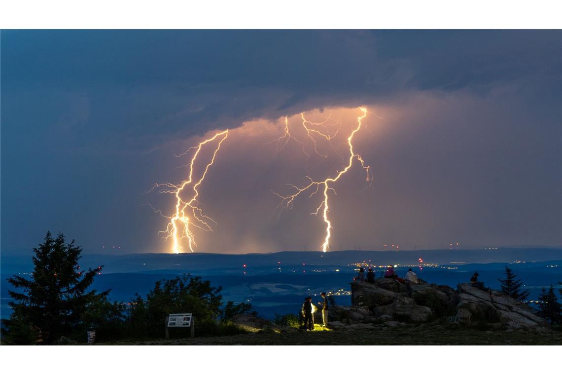 Menschen beobachten Blitze eines Gewitters am Großen Feldberg im Taunus.