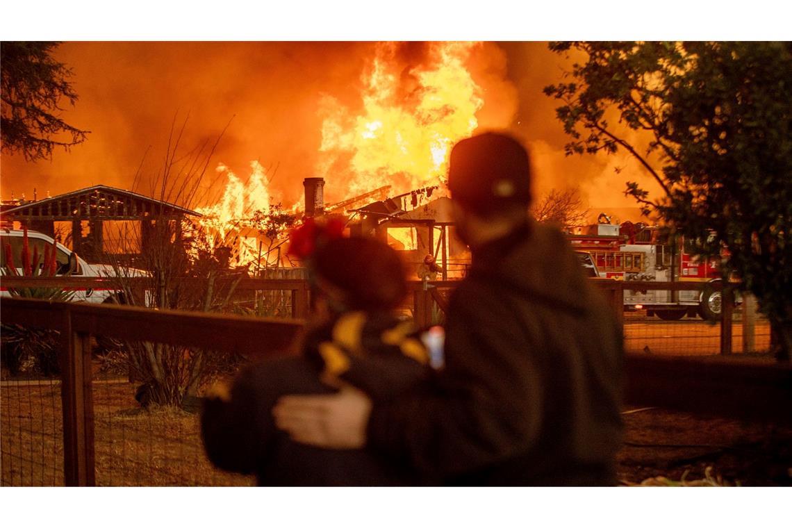 Bilder des Tages Menschen beobachten, wie das Eaton-Feuer in Los Angeles ein Gebäude verschlingt.