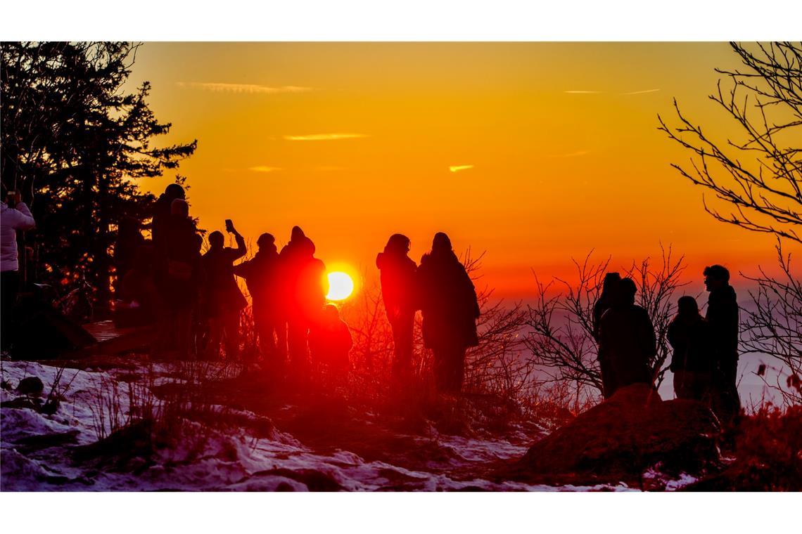 Bilder des Tages Menschen betrachten den Sonnenuntergang vom Feldberg-Plateau aus.