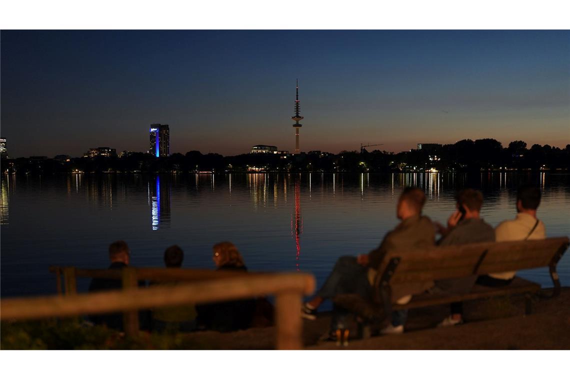 Bilder des Tages Menschen genießen die Abendstimmung am Ufer der Außenalster in Hamburg.