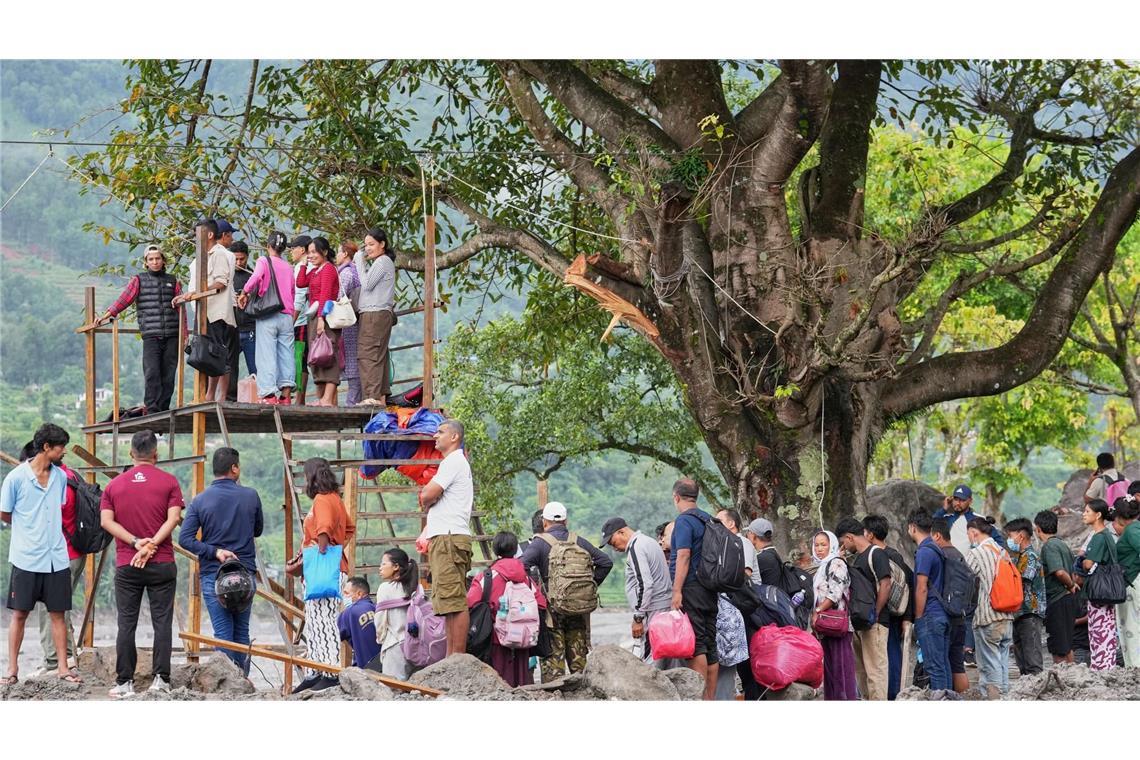 Menschen im Katastrophengebiet in Nepal warten darauf, in eine provisorische Seilbahn besteigen zu können. 