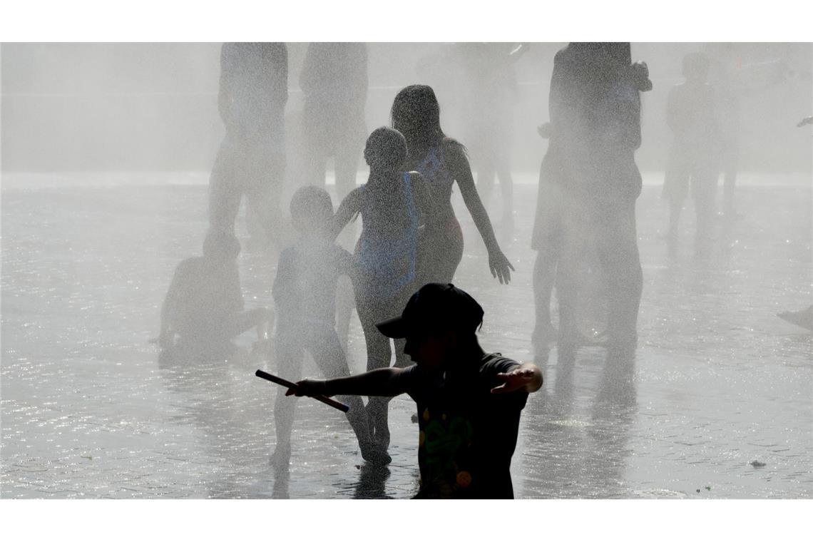 Bilder des Tages Menschen kühlen sich bei heißem Wetter in einem Brunnen in Madrid ab.