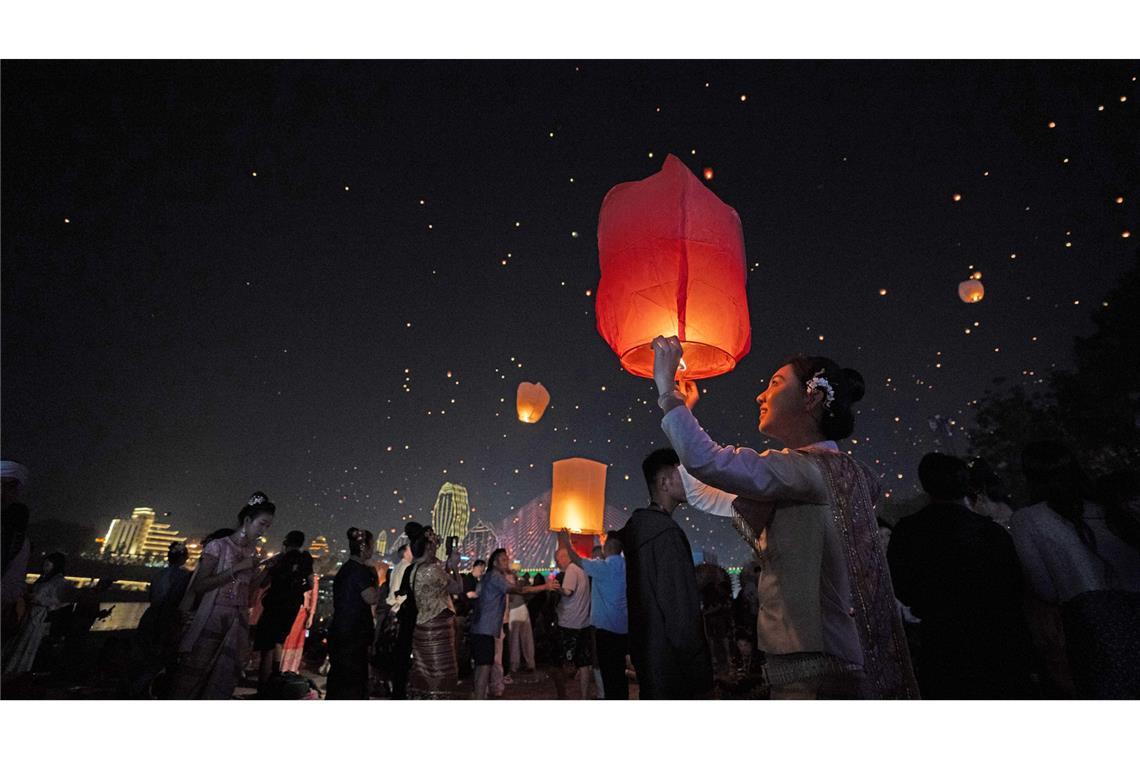 Menschen lassen Laternen steigen am Fluss Lancang in Yunnan