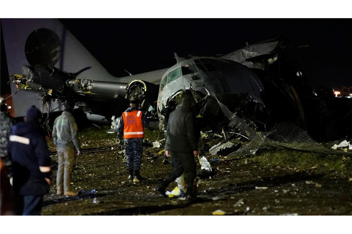 Menschen laufen an der Stelle vorbei, an der ein Flugzeug auf einer Autobahn in El Alto, Bolivien, abgestürzt ist.
