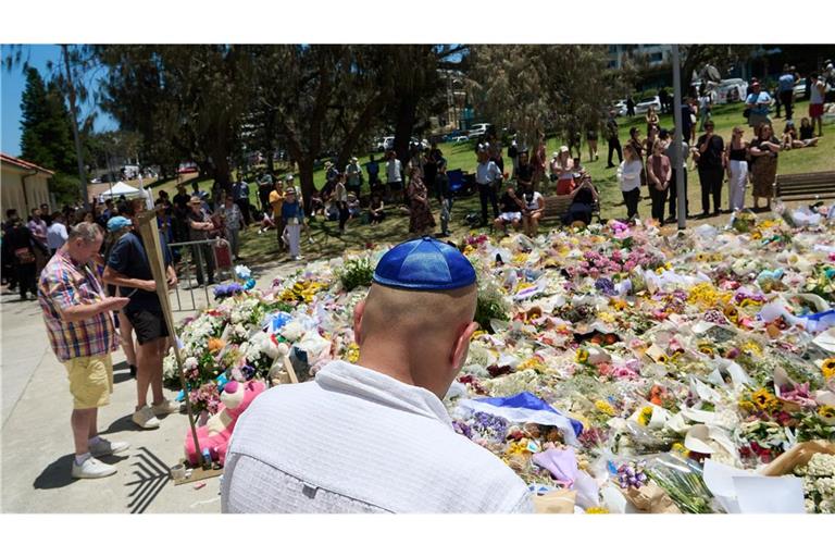 Menschen legen bei einer Gedenkfeier für die Opfer eines Terrorangriffs am Bondi Beach in Sydney Blumen nieder. (Foto aktuell)