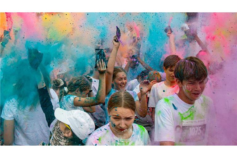 Menschen nehmen am Color Run in Jūrmala teil.Der 5 km lange Lauf findet im Kauguri-Park statt, wo die Teilnehmer mit Farbpulver und Schaum beworfen werden.