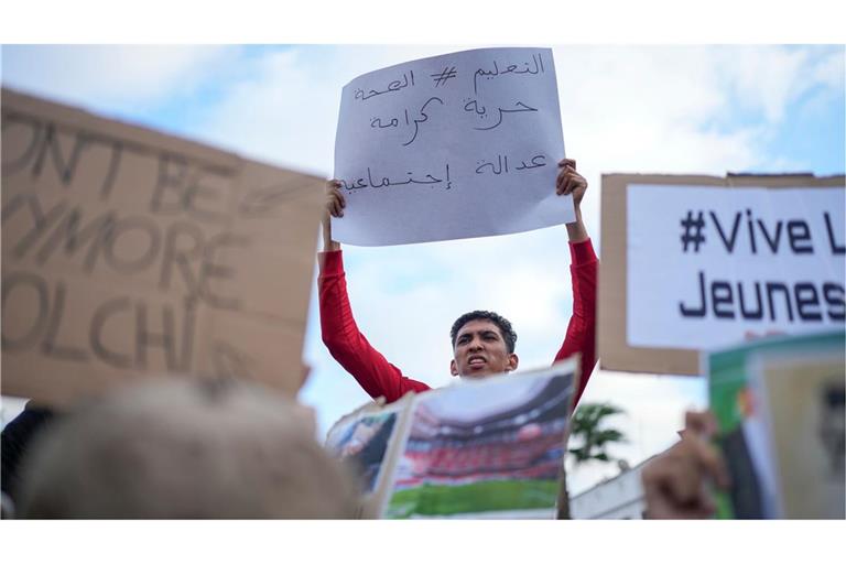 Menschen nehmen an einem von Jugendlichen angeführten Protest gegen Korruption und für Reformen im Gesundheits- und Bildungswesen in Casablanca, Marokko, teil. Auf dem arabischen Transparent steht „Bildung, Gesundheit, Freiheit, Würde und soziale Gerechtigkeit“.