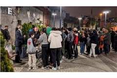 Menschen sammeln in einer Verteilstelle für Lebensmittel.