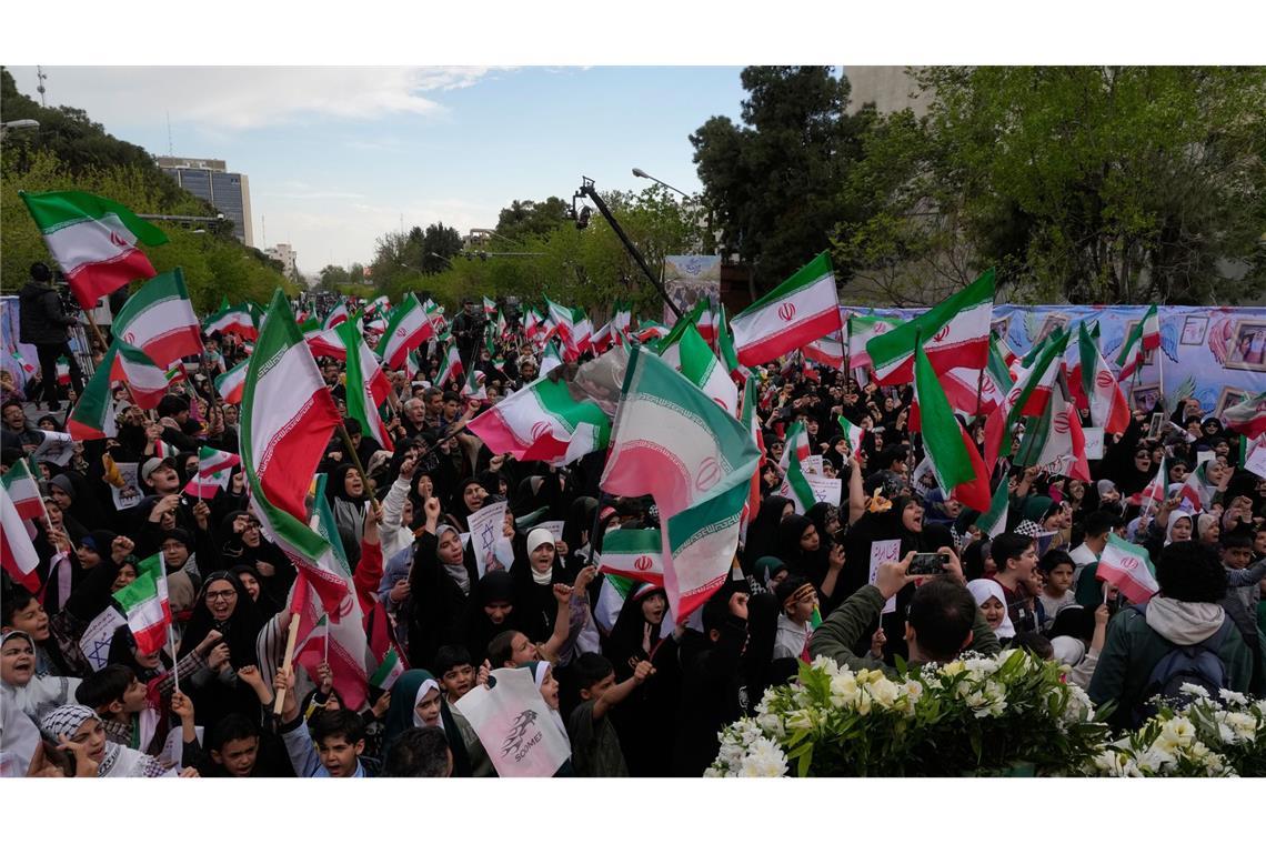 Menschen schwenken iranische Fahnen bei einer Gedenkfeier für Schulkinder, die am 28. Februar bei einem US-Luftangriff auf eine Schule in  Minab getötet wurden.