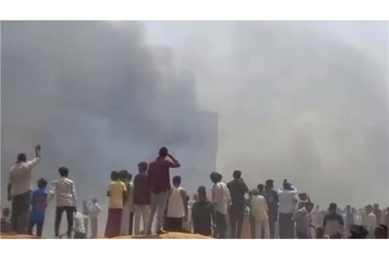 Menschen sehen Rauch aufsteigen, nachdem ein Flugzeug in Ahmedabad im indischen Bundesstaat Gujarat abgestürzt ist.