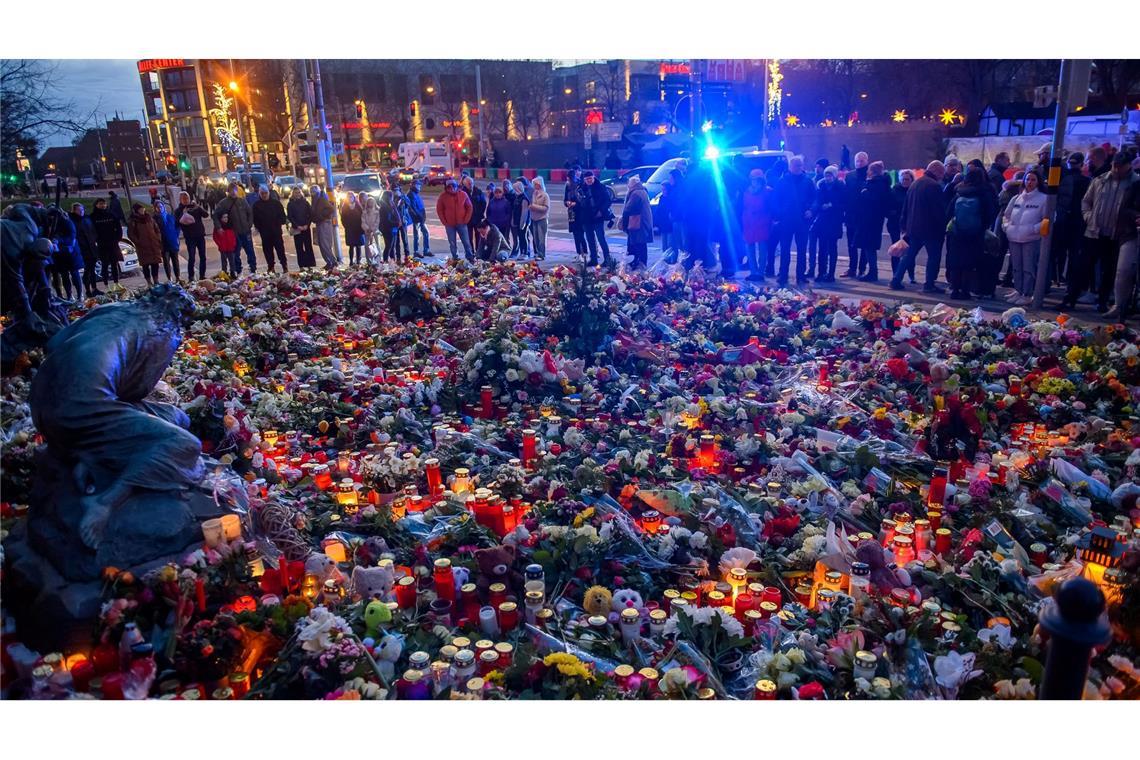 Bilder des Tages Menschen stehen vor der Johanniskirche in Magdeburg, wo ein Gedenkort eingerichtet und Blumen und Kerzen niedergelegt wurden.