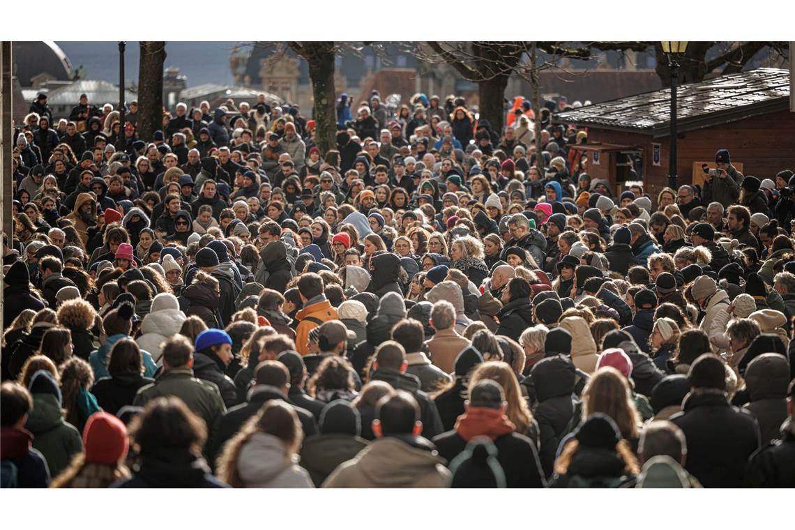 Menschen stehen zusammen während einer Schweigeminute bei der Trauerfeier für die Opfer des verheerenden Brandes in Crans-Montana in der Schweiz.