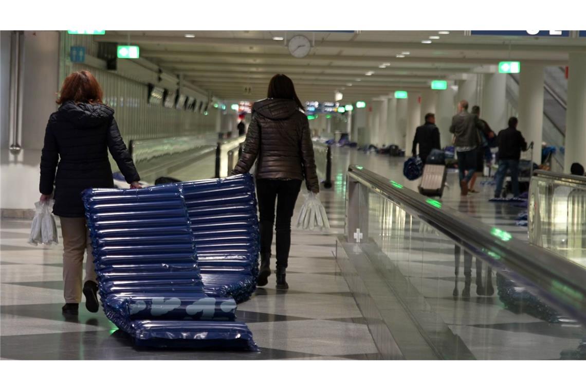 Bilder des Tages Menschen tragen nach möglichen Drohnensichtungen am Flughafen München Luftmatratzen.