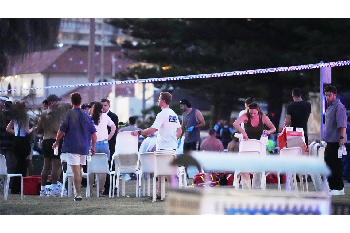 Menschen und Rettungskräfte versammeln sich am Bondi Beach in Sydney, wo eine Festtagsveranstaltung stattfand und anschließend ein Zwischenfall gemeldet wurde.