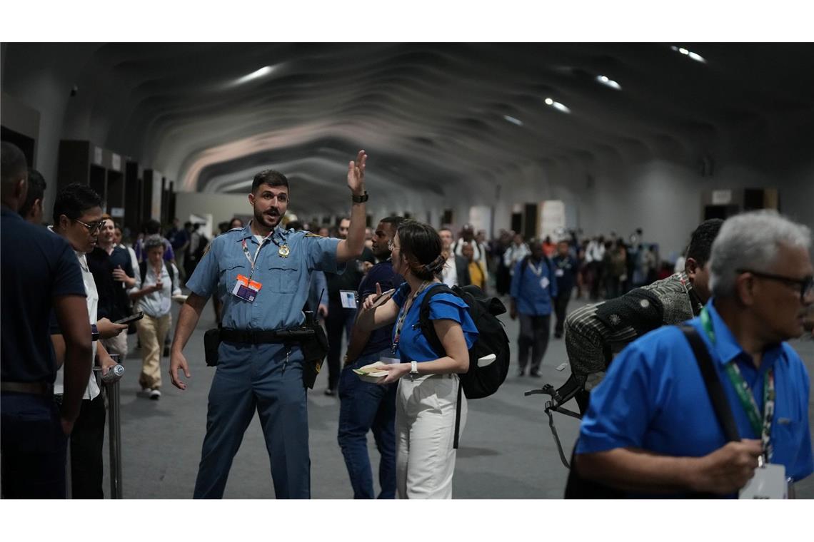 Menschen verlassen das Gelände der Weltklimakonferenz COP 30 wegen eines Feuers.