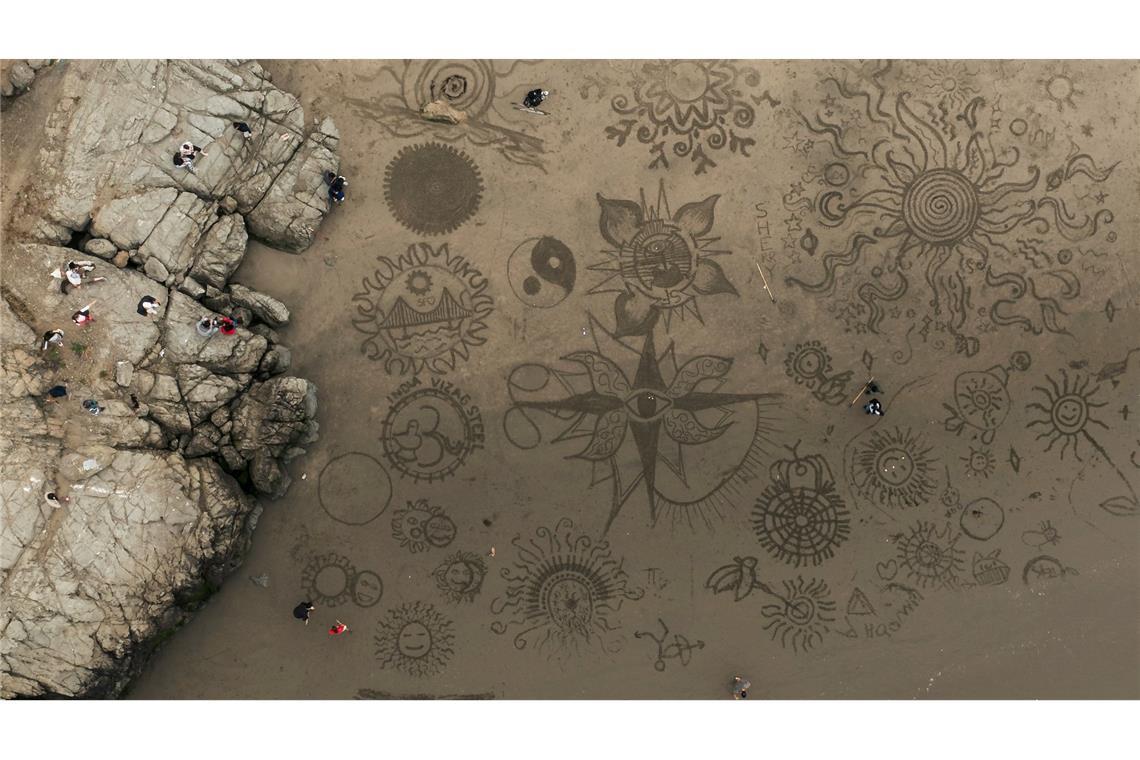 Menschen versammeln sich am Ocean Beach in San Francisco, um bei einer von Künstler Andres Amador organisierten Veranstaltung Kunstwerke im Sand zu gestalten.