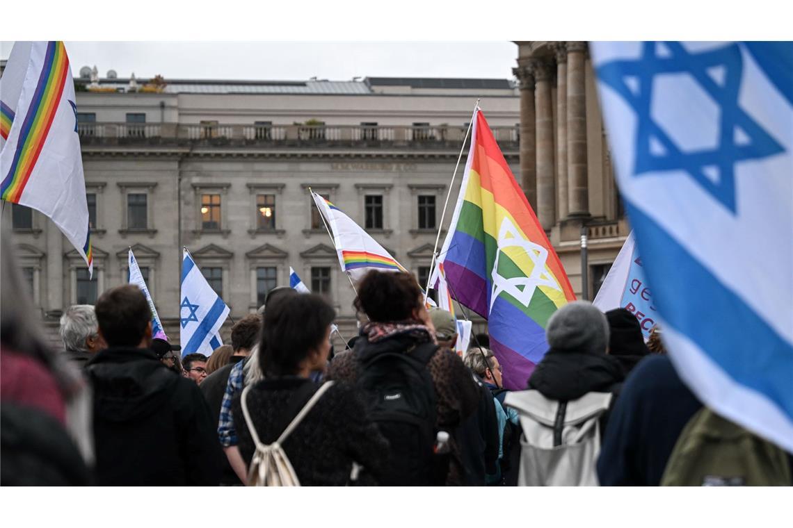 Brandenburger Tor zum Gedenken an 7. Oktober angestrahlt Menschen versammeln sich auf dem Bebelplatz zu einer Mahnwache zum 7. Oktober 2023.