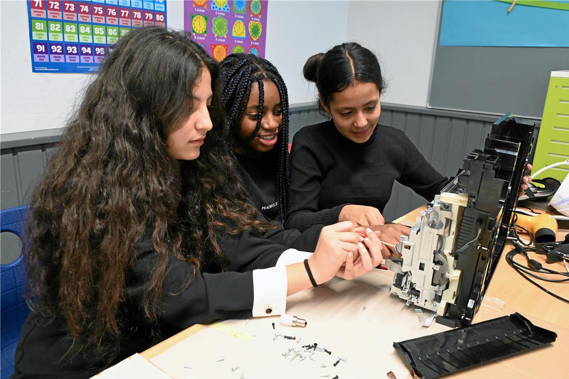 Technikwerkstatt trifft Kreativität Meral (von links), Grace und Gita sind gerade dabei, einen Drucker auseinanderzunehmen. Teile des ausgedienten Geräts möchten sie für ihr geplantes Kunstobjekt verwenden. Foto. Elisabeth Klaper