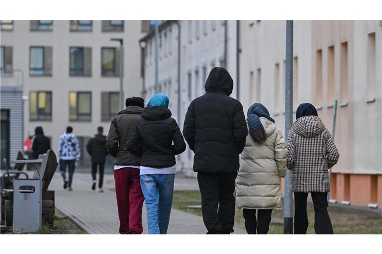 Migranten gehen über das Gelände einer Erstaufnahmeeinrichtung (Symbolbild).