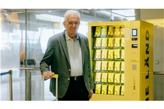 Ministerpräsident Winfried  Kretschmann vor dem „Nett-hier“-Sticker-Automat am Flughafen.