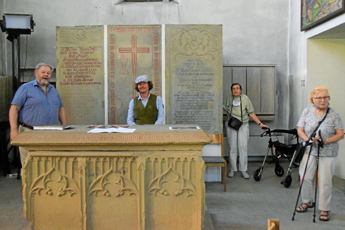 Vielfältig verbunden Mit Christian Schweizer (links) ging es auf den Spuren Hölderlins auch in die Murrhardter Gotteshäuser – hier in der Stadtkirche zeigt er die Grabsteine der Familie Haselmaier und erläutert die verwandtschaftlichen Verbindungen. Foto: E. Klaper