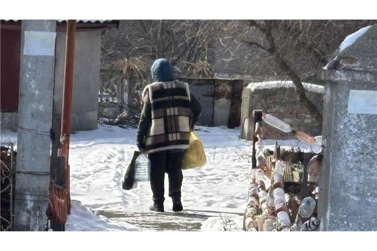 Mit dem Einkauf für eine Woche bepackt macht sich Tetiana auf dem zehneinhalb Kilometer langen Rückweg aus dem belagerten Pokrovsk ins Dorf Rodynske.