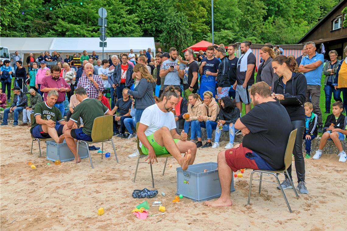 Wasserspiele beim Fornsbacher Sommernachtsfest Mit den Füßen fischen die Teilnehmer Treibgut aus den mit Wasser gefüllten Kisten.