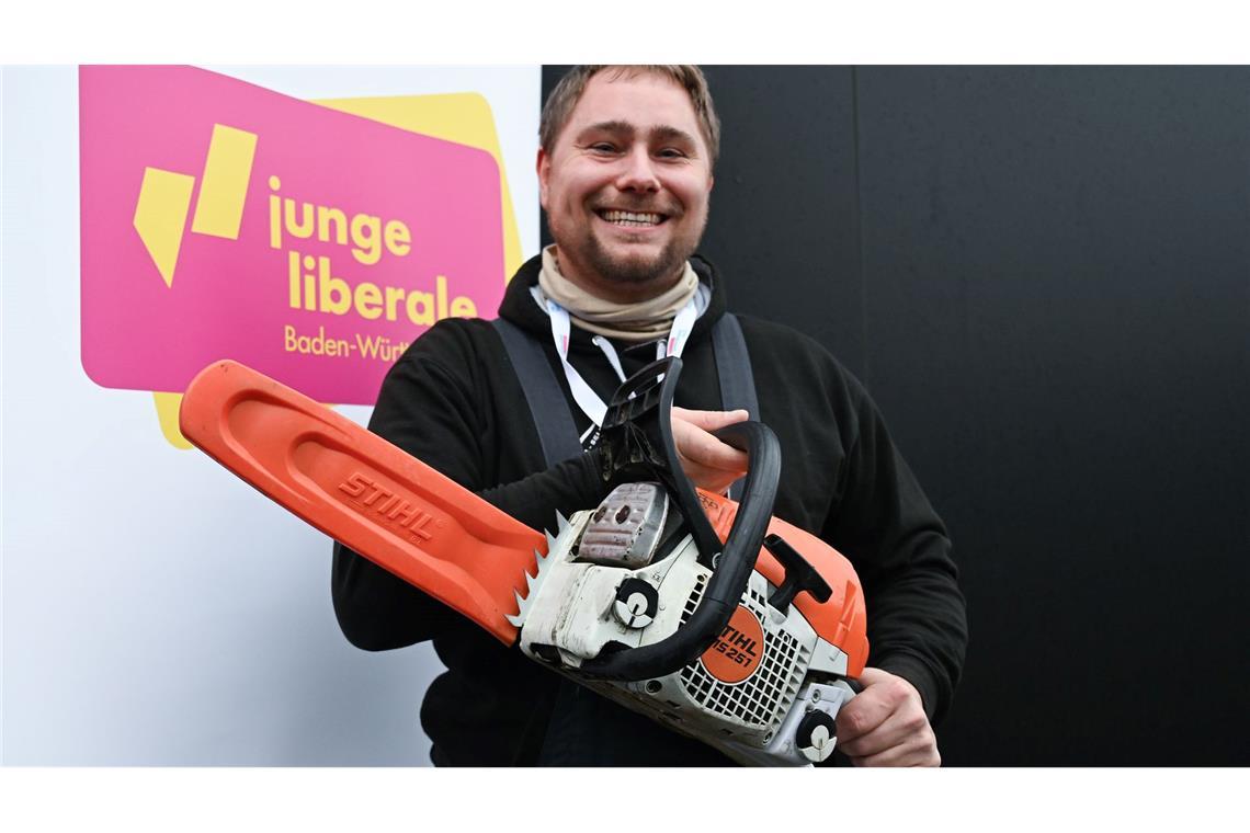 Nur wenige Wähler rechnen mit Wirtschaftswende nach der Wahl Mit der Kettensäge will Mark Hohensee, Landesvorsitzender der Jungen Liberalen, packt für den Bürokratieabbau symbolisch die Kettensäge aus.