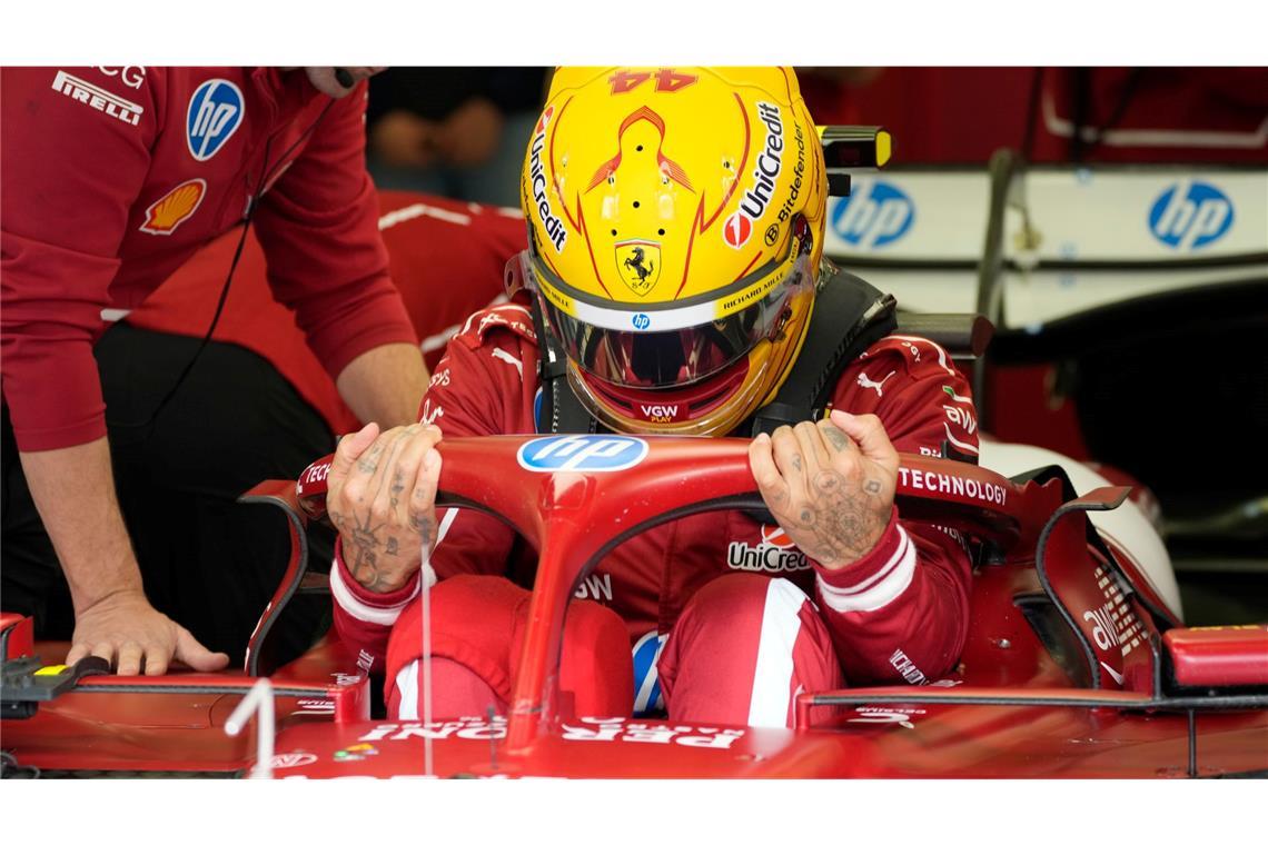 Hamilton und die Last der Ferrari-Liebe Mit gelbem Helm im roten Auto.