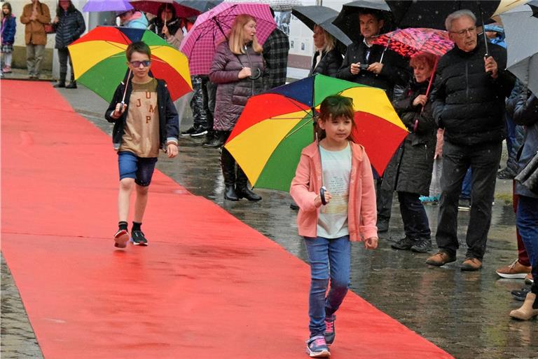 Mit Regenschirmen ausgestattet wurden die Models über den 100 Meter langen roten Teppich als Laufsteg geschickt. Fotos: E. Klaper