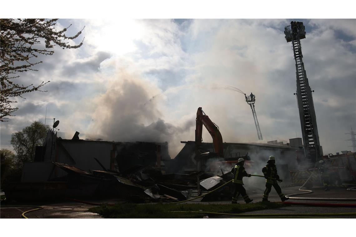 Mit schwerem Gerät arbeitet sich die Feuerwehr zu Glutnestern vor nach einem Brand in einem Club.