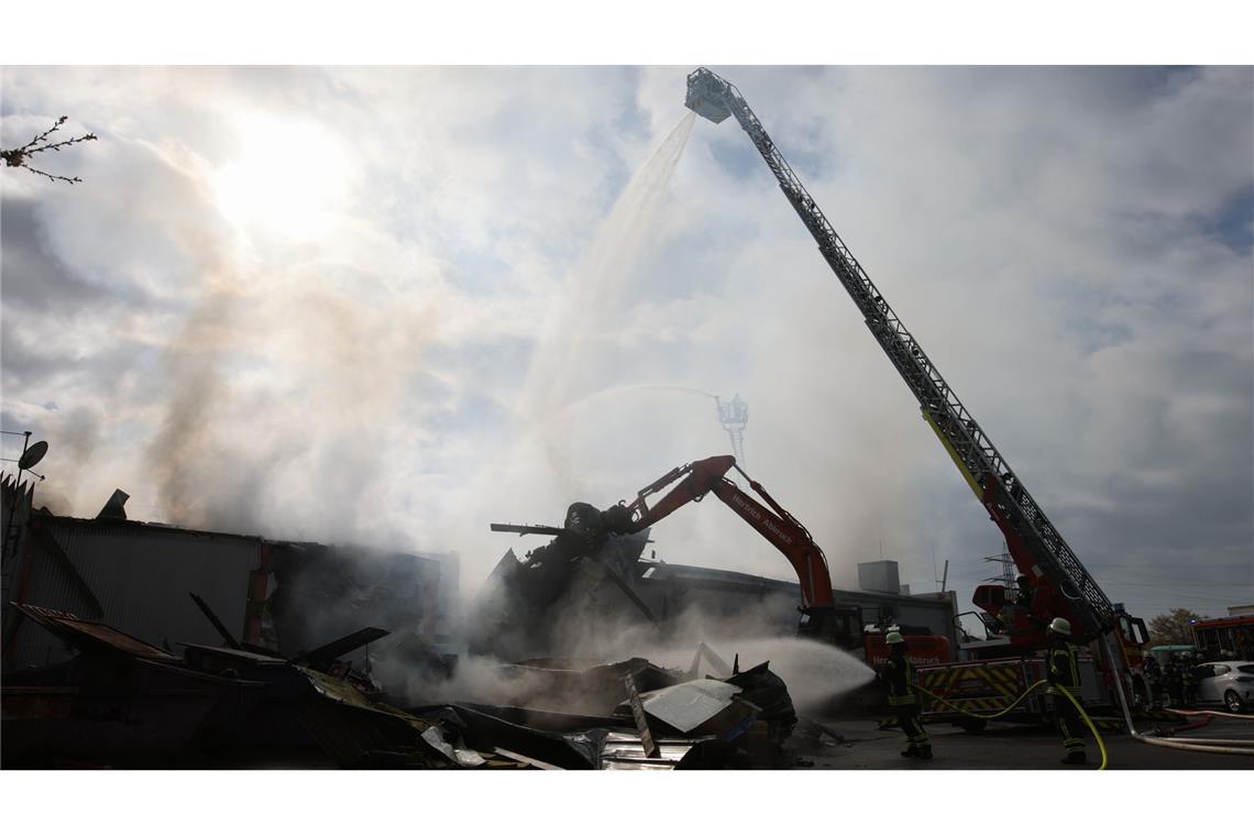 Mit schwerem Gerät arbeitet sich die Feuerwehr zu Glutnestern vor nach einem Brand in einem Club.