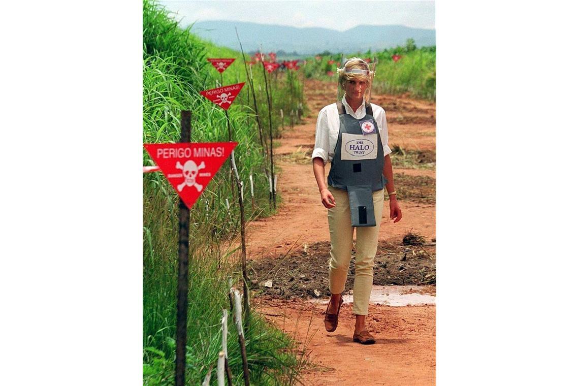 Mit Splitterschutz-Weste und Glasvisier geht Prinzessin Diana in Huambo in Angola durch ein Minenfeld, um zu erfahren, mit welchen Angstgefühlen die einheimische Bevölkerung leben muss.