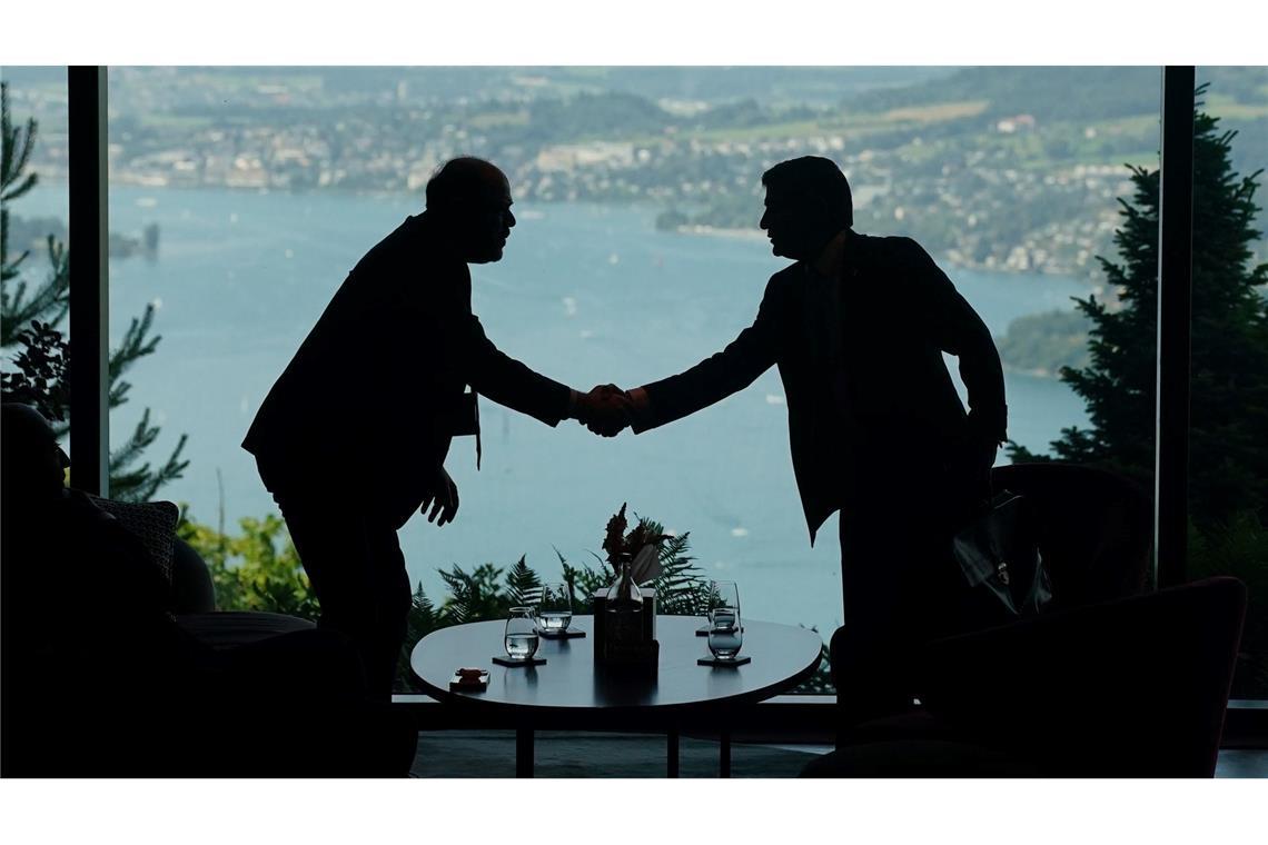 Mitarbeiter der Delegationen geben sich im Rahmen eines Treffens zwischen den USA, dem Iran, Pakistan und Katar die Hand.